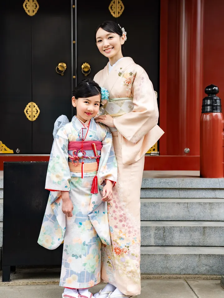 在神社前和母亲站在一起的7岁女孩穿着和服